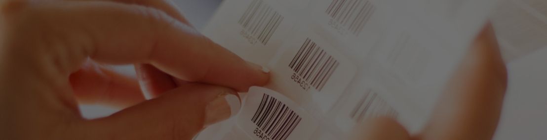 Worker peeling barcode label off a product sheet
